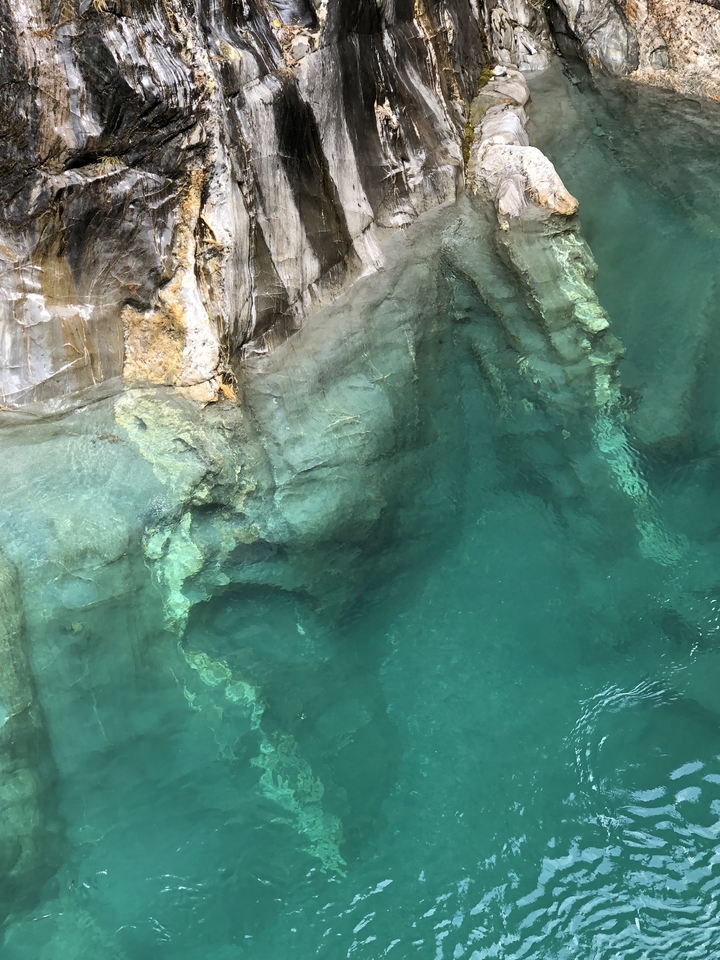 Gros plan d'une eau turquoise claire contre des formations rocheuses.