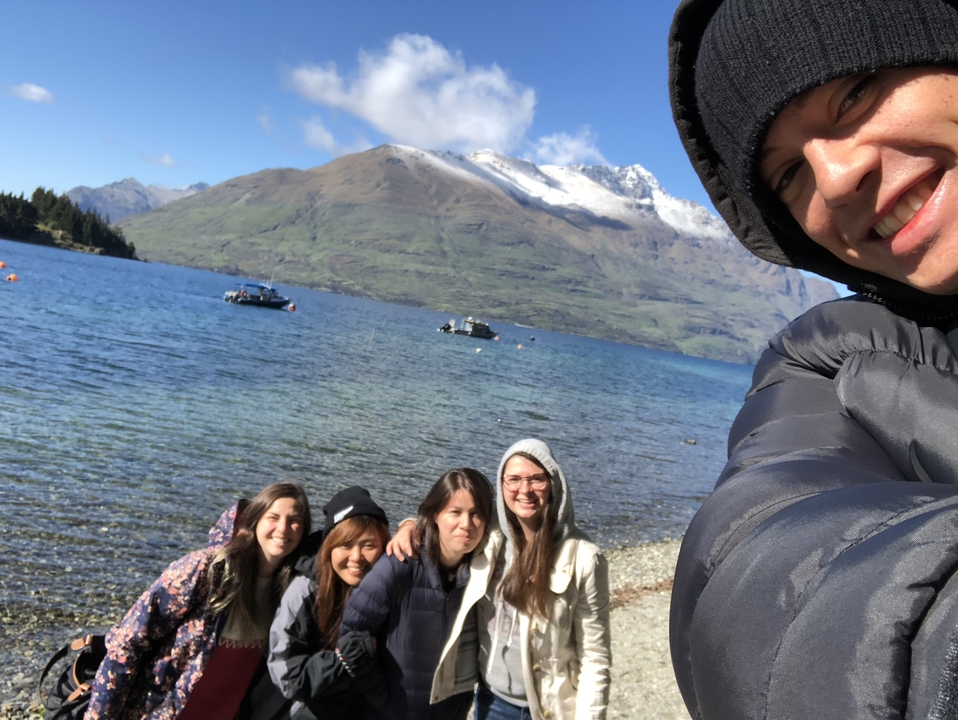 Groupe d'amis prenant un selfie au bord d'un lac.