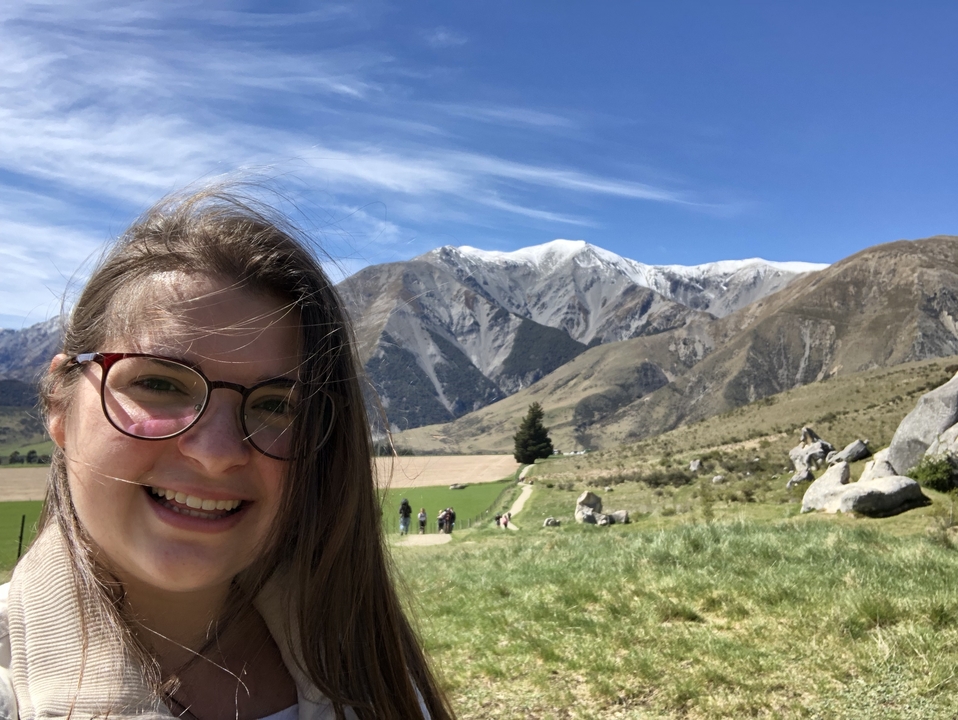 Femme prenant un selfie avec un paysage de montagnes en arrière-plan.