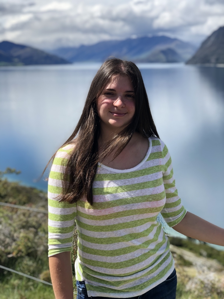 Femme souriante devant un plan d'eau.