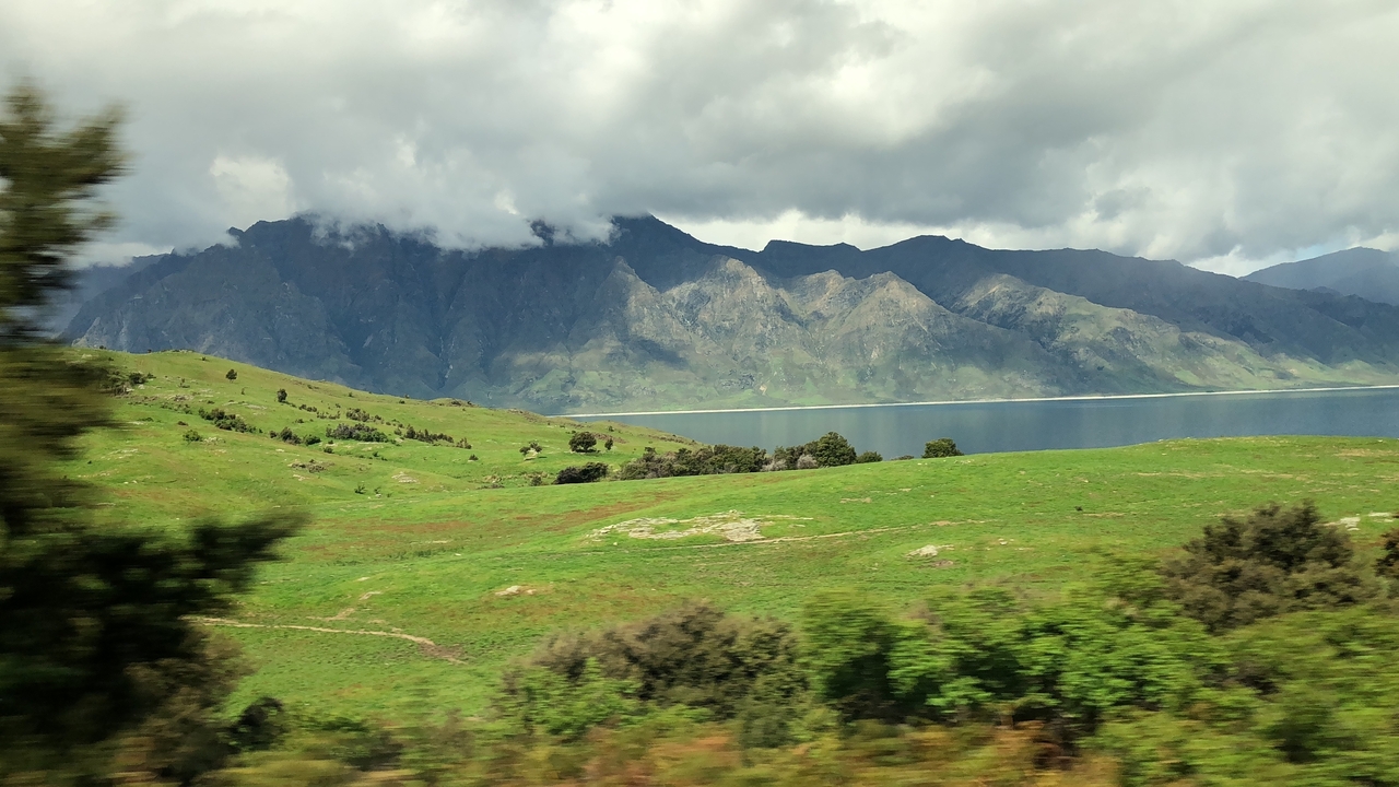 Colline verdoyante avec des montagnes en arrière-plan.