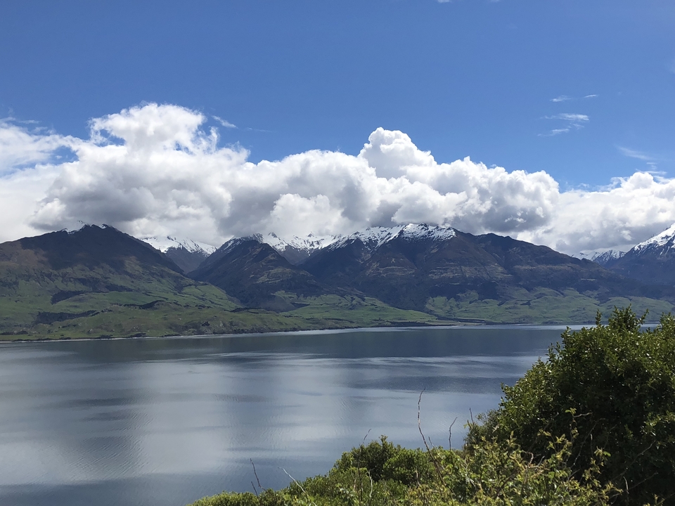 Serene lake with cloud-covered mountain range.