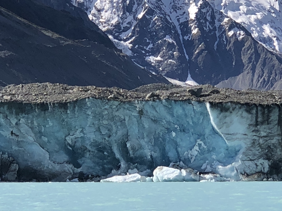 Mur de glace glaciaire avec montagne en arrière-plan.
