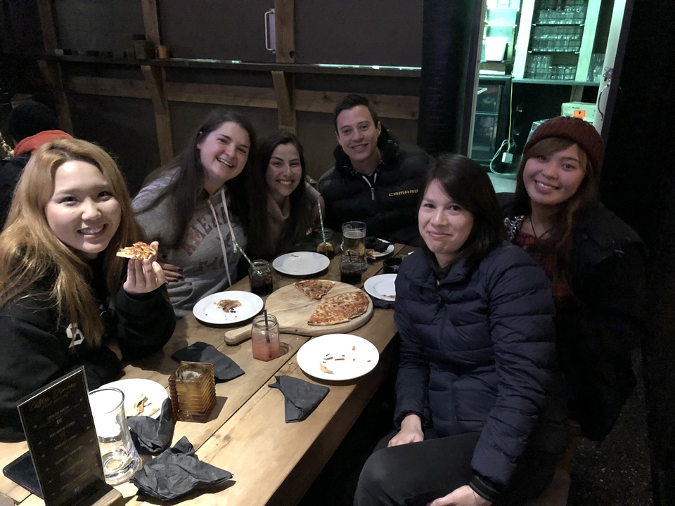 Des amis qui savourent une pizza dans un restaurant.