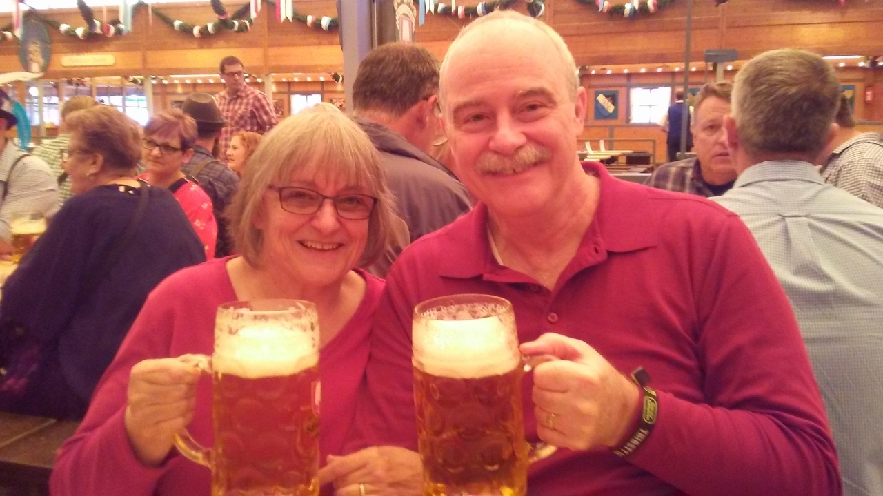 Couple tenant de grandes chopes de bière dans un cadre festif