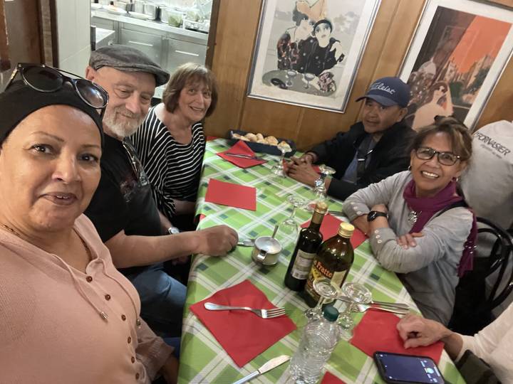 Groupe de personnes à une table avec de la nourriture et des boissons.