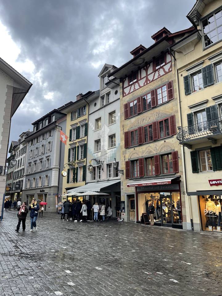 Des gens debout dans une rue pavée entourée d'architecture historique.