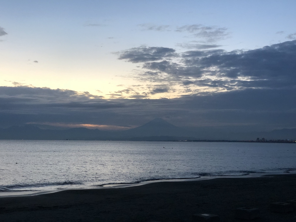 Vue côtière avec montagnes en arrière-plan au crépuscule.