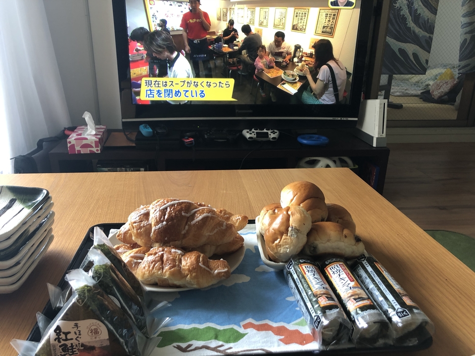 Des articles alimentaires disposés sur une table devant une télévision.