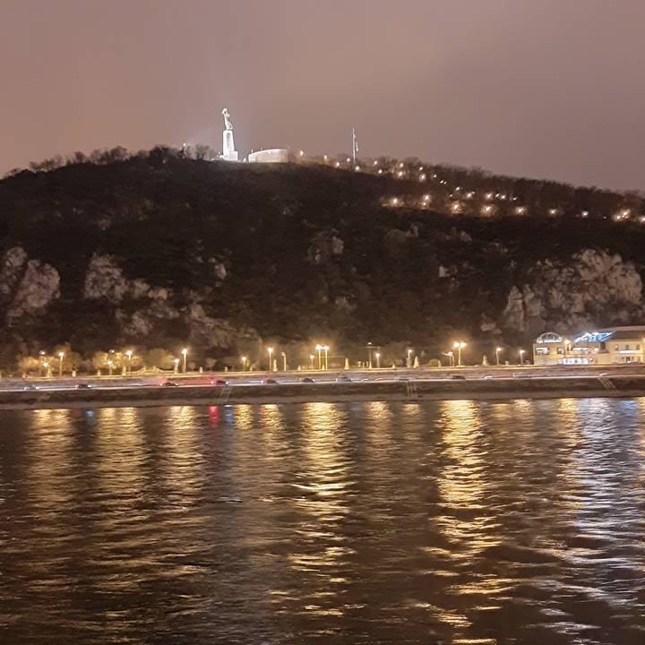 Paysage reflétant les lumières sur l'eau la nuit.