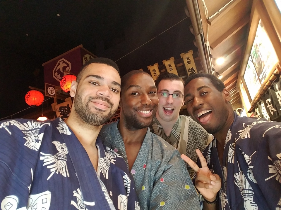 Quatre amis en tenue traditionnelle qui prennent un selfie.