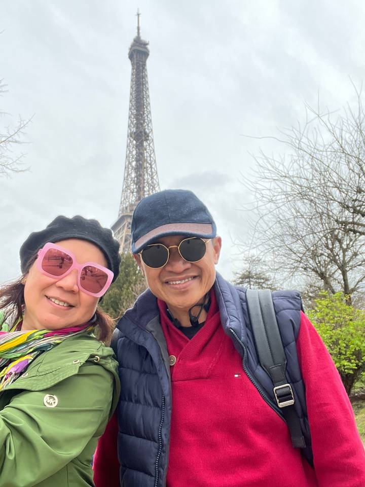 Deux personnes posant avec la tour Eiffel en arrière-plan.