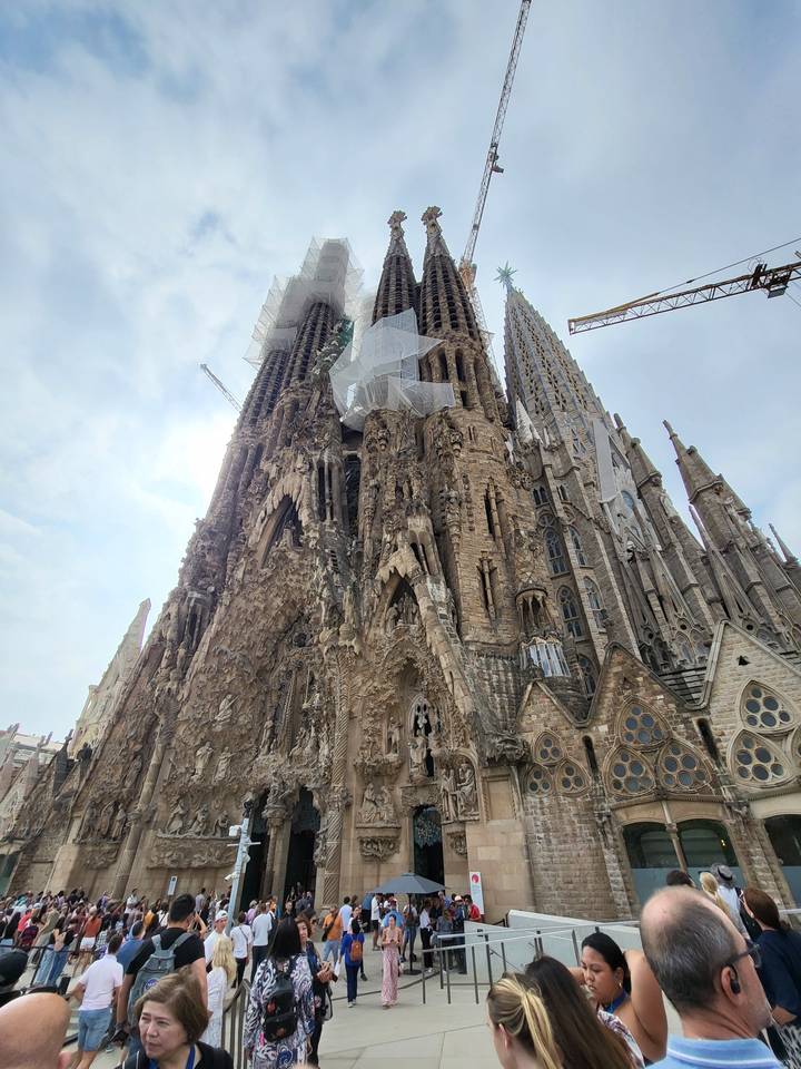 Une architecture vaste et complexe avec des touristes rassemblés autour.