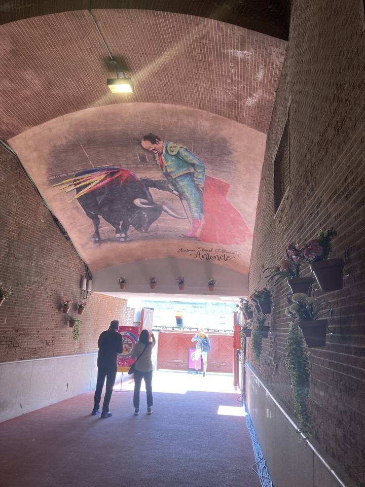 Fresque représentant une corrida dans un corridor voûté.