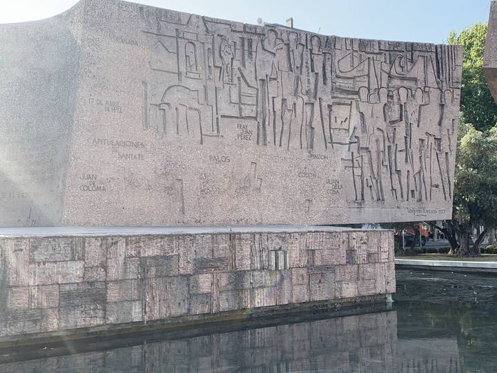 Sculpture en pierre avec inscriptions exposée en plein air.