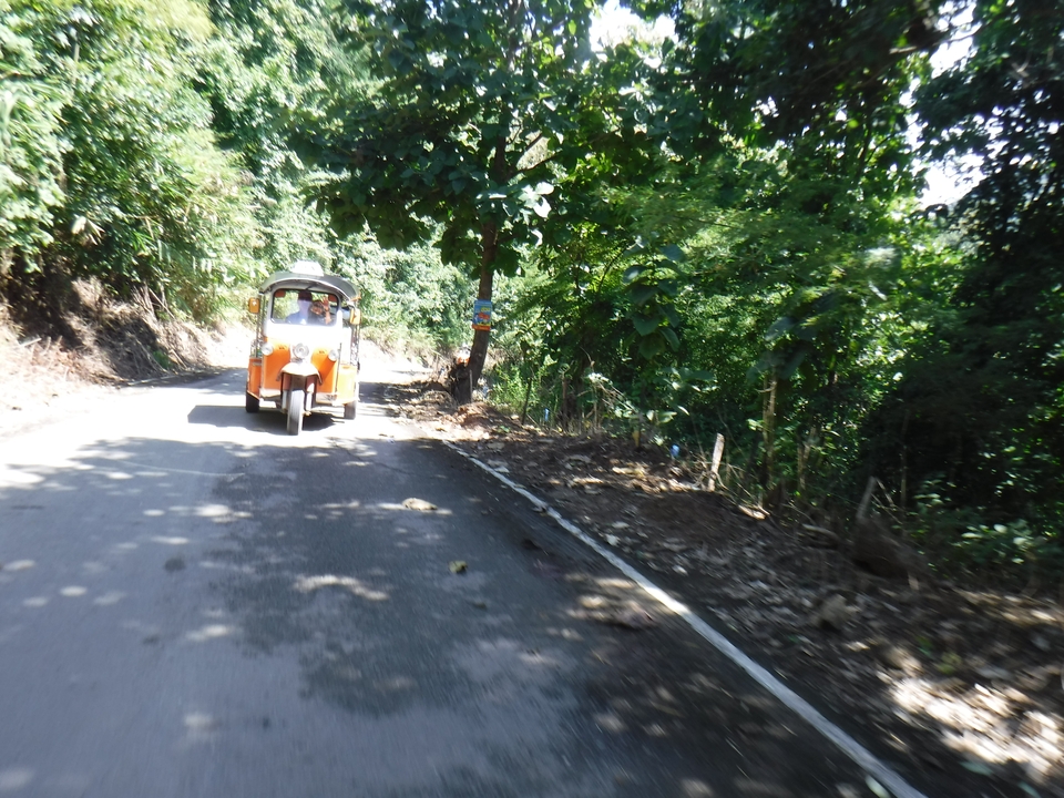 Tuk-tuk roulant sur un sentier de jungle.