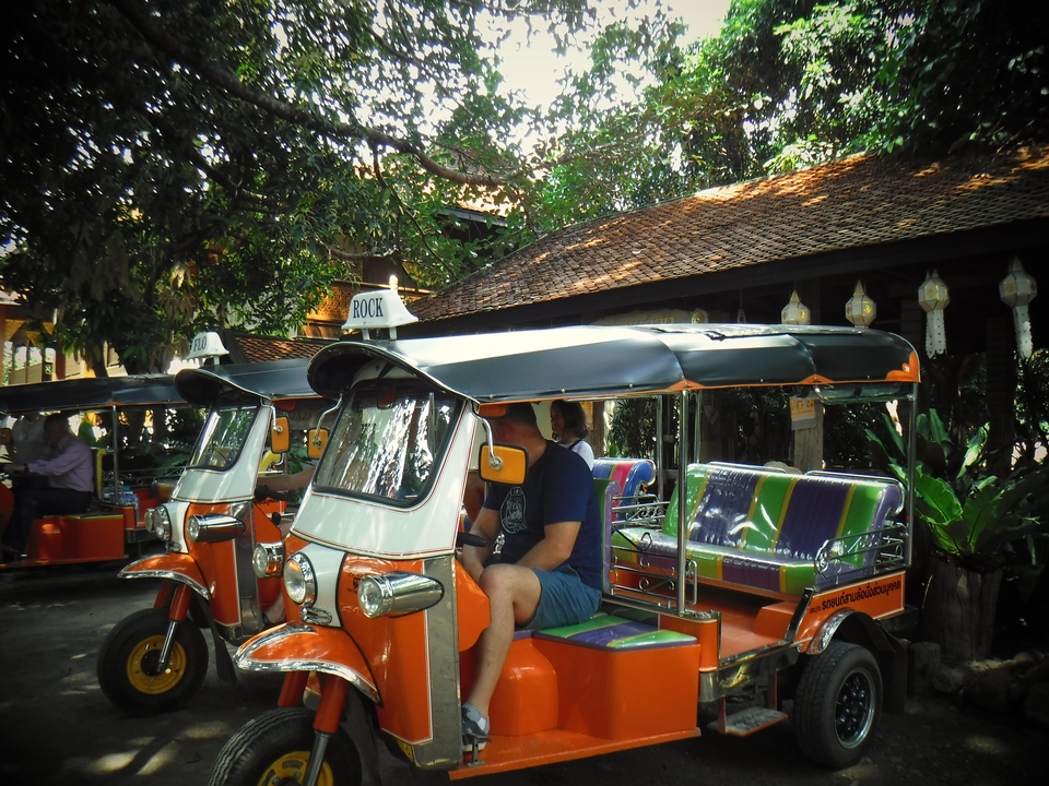 Des tuk-tuks garés devant un bâtiment.