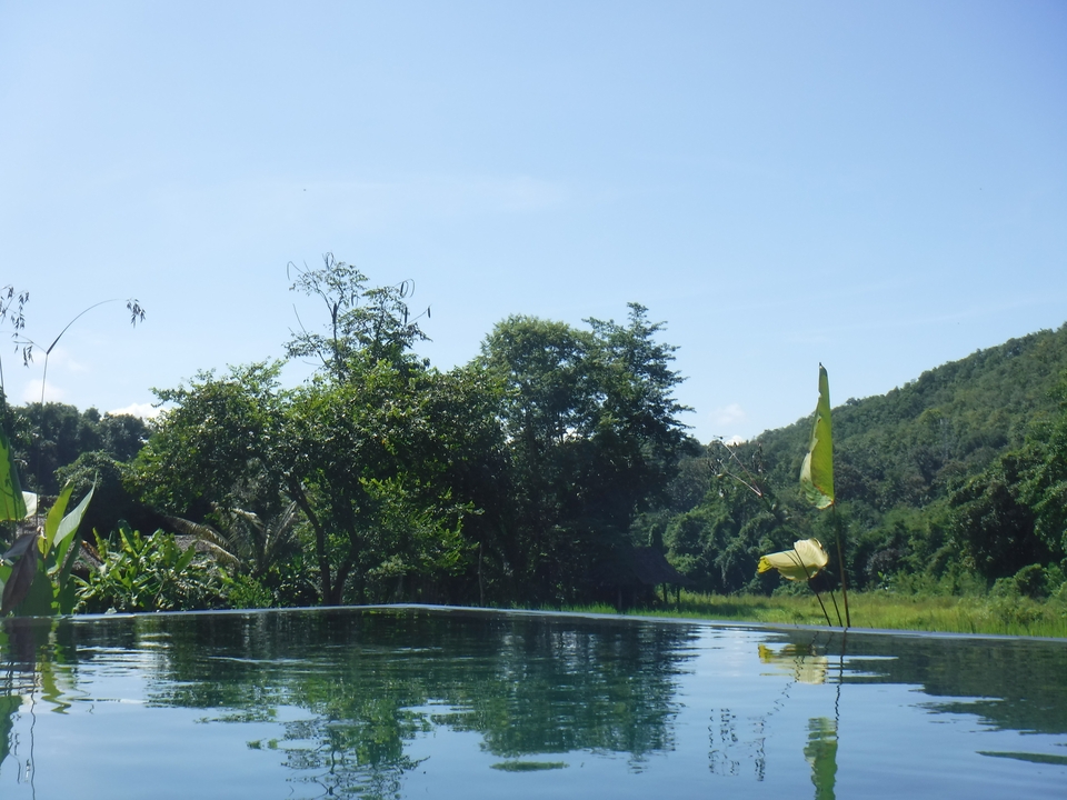 Vue naturelle avec une piscine qui se fond dans le paysage.