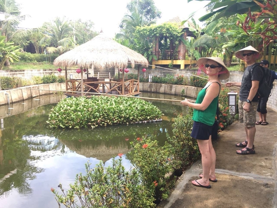 Deux personnes pêchant dans un cadre tropical luxuriant.