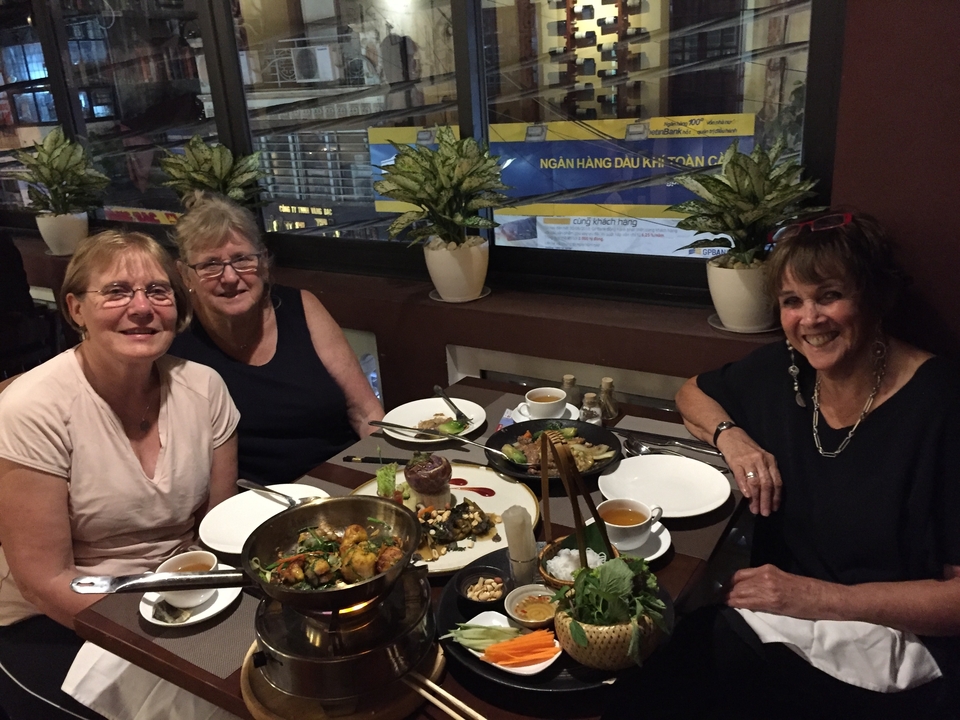 Trois femmes dînant dans un restaurant avec des plats sur la table.