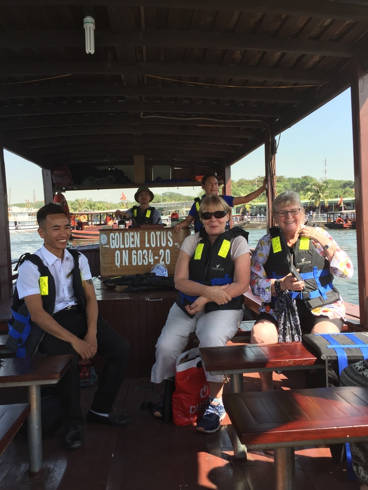 Groupe de personnes sur un bateau portant des gilets de sauvetage.