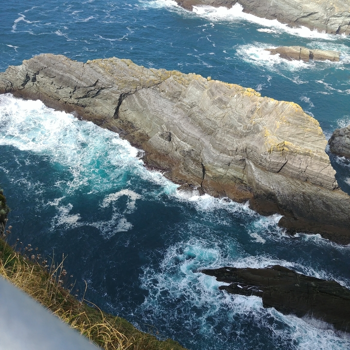 Falaise rocheuse avec les vagues de l'océan qui se brisent en contrebas.
