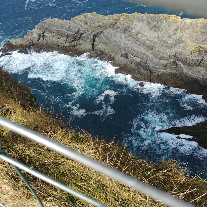 Vue sur l'océan avec des vagues qui frappent la falaise.