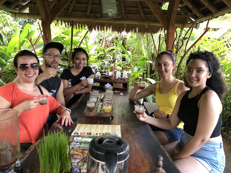 Groupe prenant des verres et dégustant des boissons dans un cadre luxuriant.