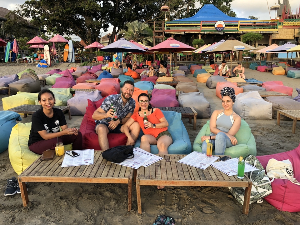 Des gens savourant des boissons dans un bar de plage coloré.
