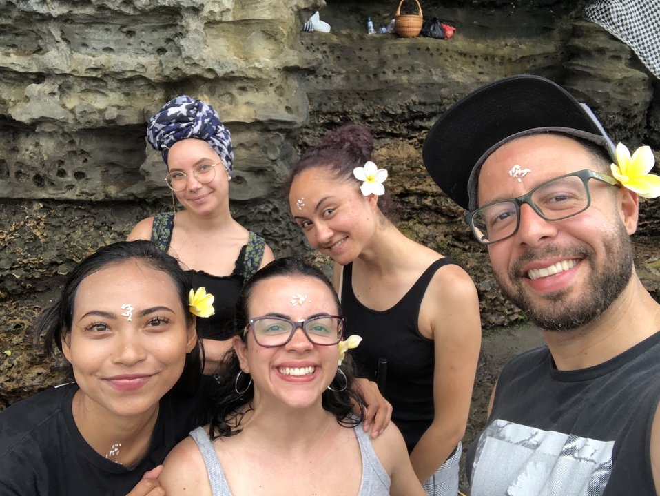 Des amis souriants qui posent avec des fleurs dans les cheveux.
