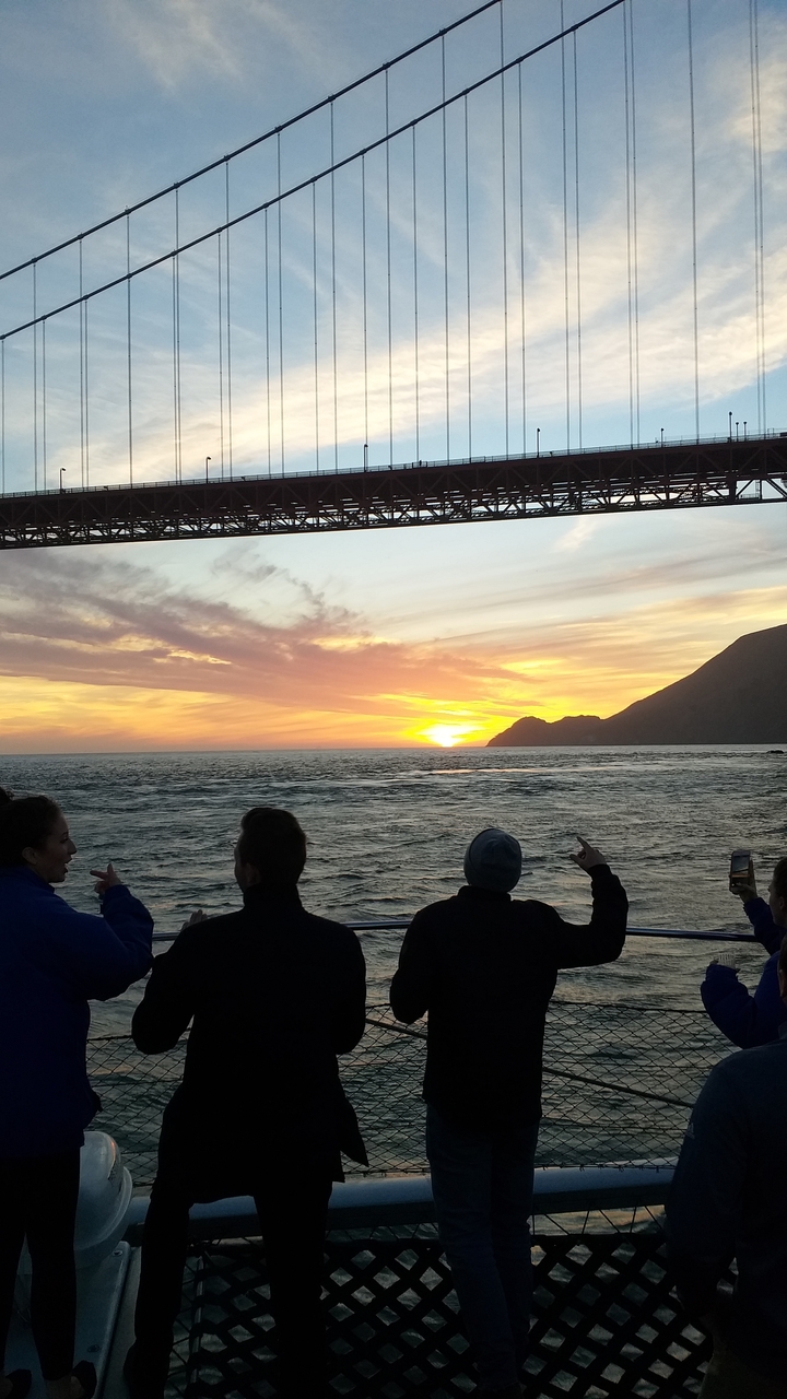 Un coucher de soleil sur l'océan avec le Golden Gate Bridge.