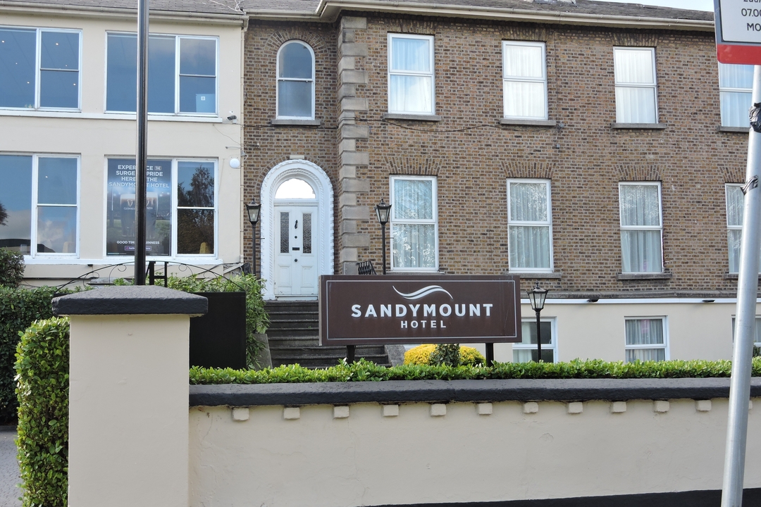 Panneau de l'hôtel Sandymount devant un bâtiment en brique.
