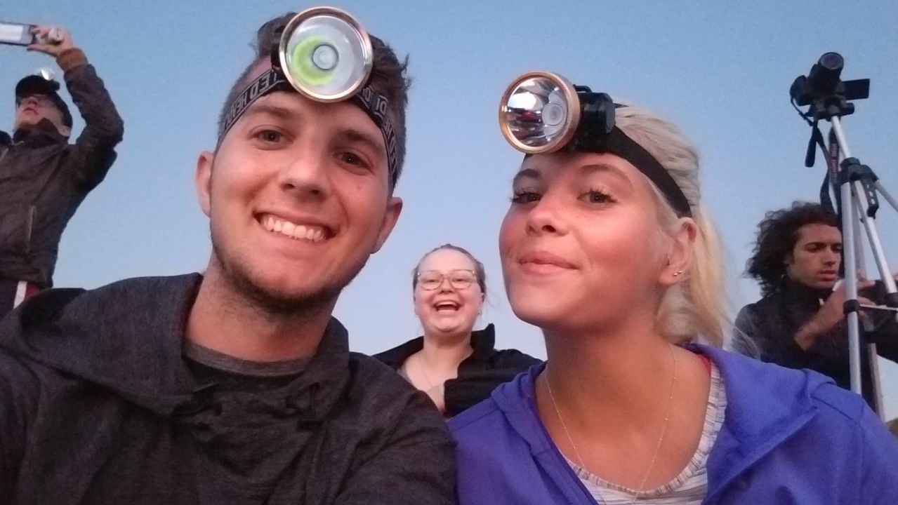 Amis portant des lampes frontales avec des caméras en arrière-plan.