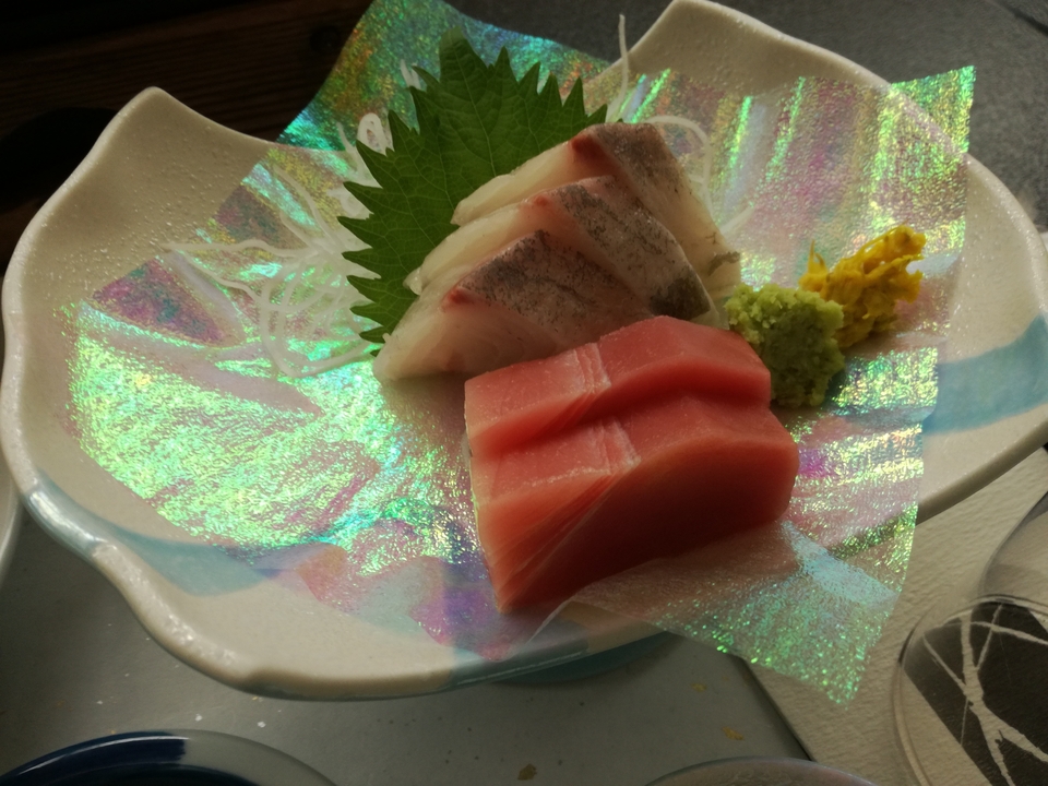 Sashimi servi sur une assiette décorative.