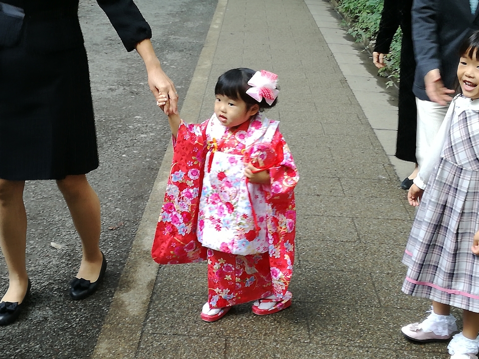 Enfant en tenue traditionnelle japonaise tenant la main d'un adulte.