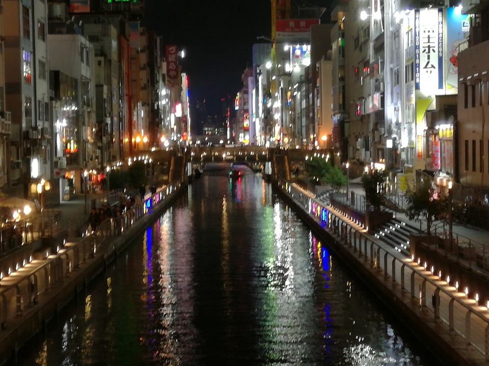 Canal éclairé avec des reflets de lumières la nuit.