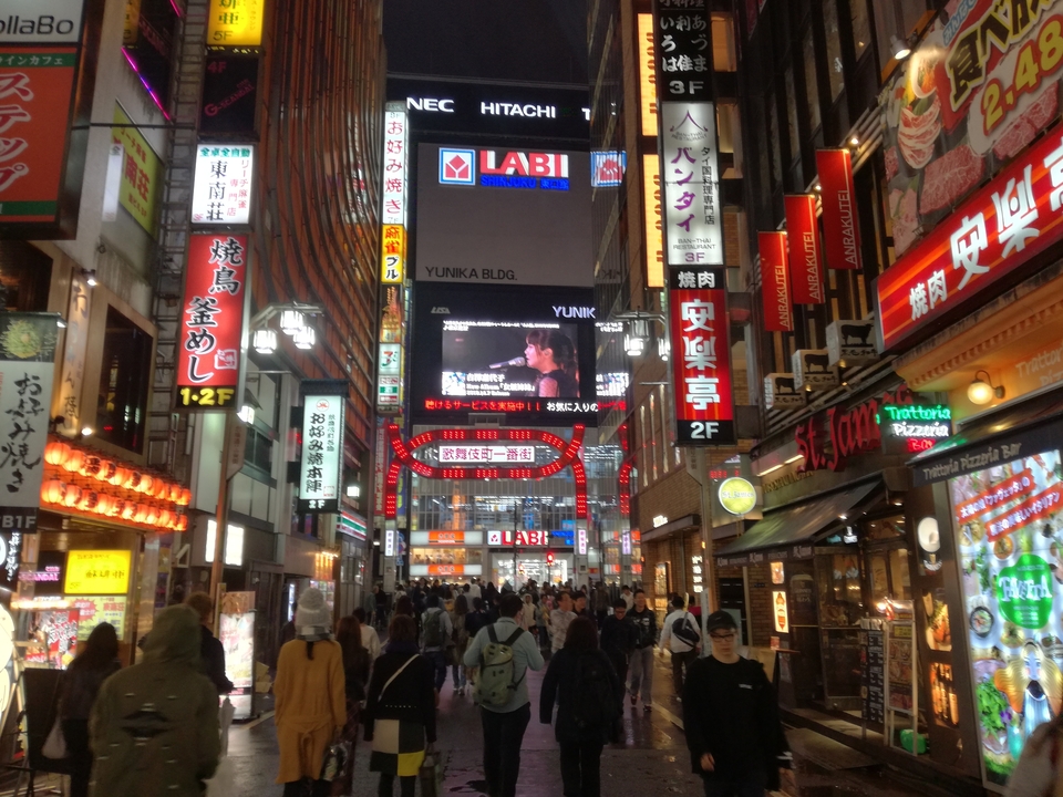 Rue animée d'une ville japonaise avec des enseignes au néon.