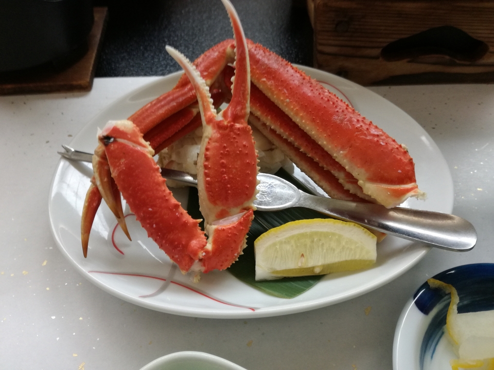 Une assiette de pattes de crabe et de citron sur une table.