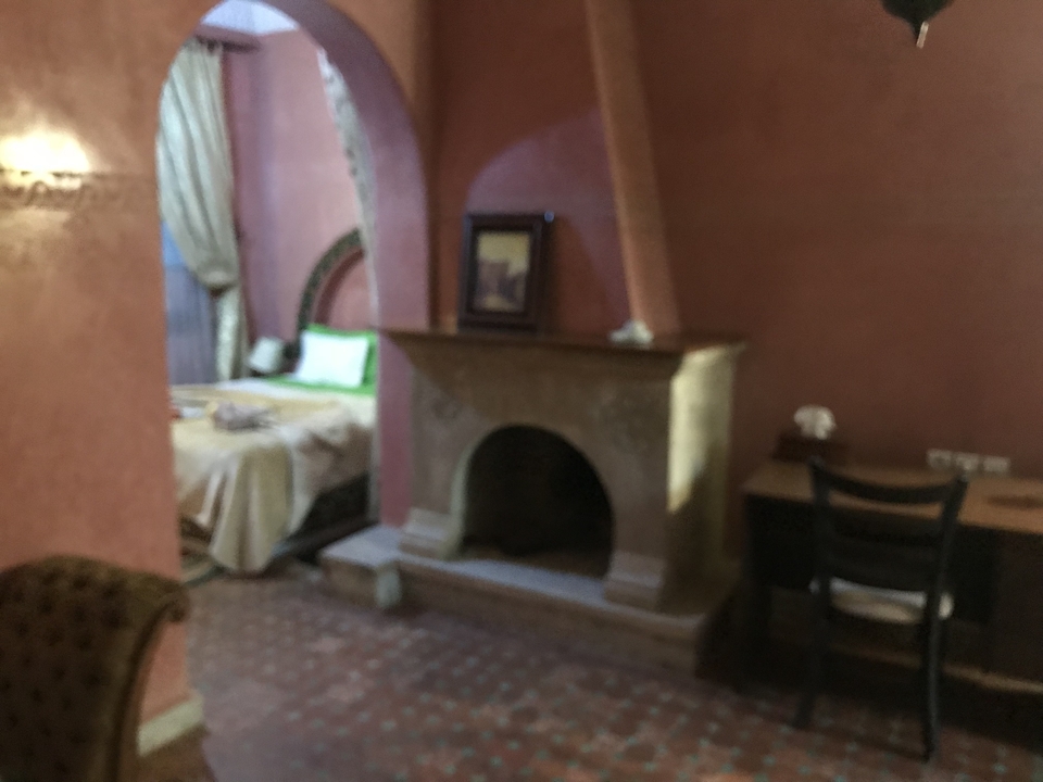 Une image floue d'une chambre avec une cheminée et un lit.
