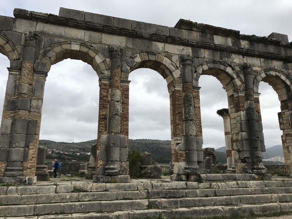 Ruines d'une ancienne cité romaine avec des arcs et des colonnes.
