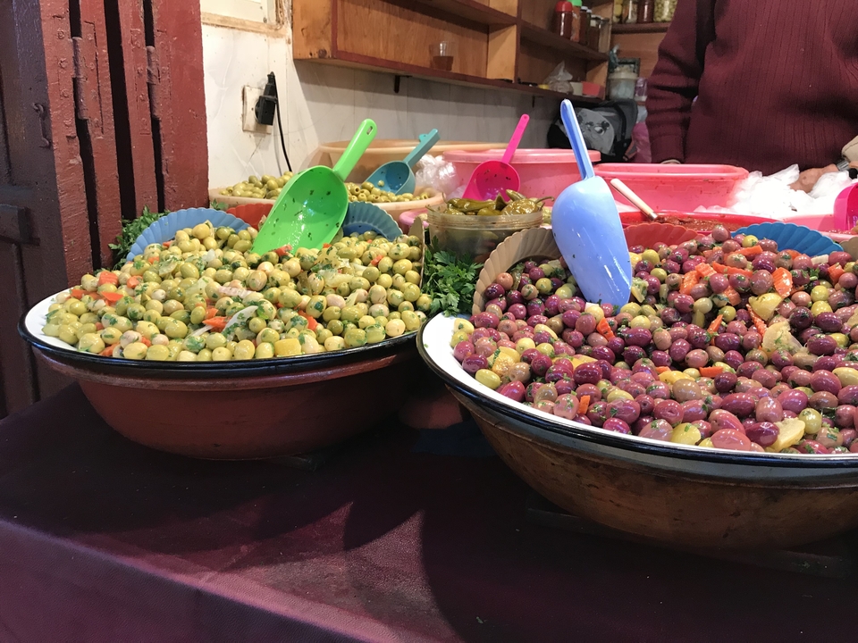 Gros plan d'un étal de marché marocain avec diverses olives.