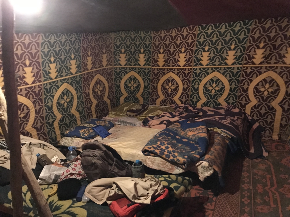 Intérieur d'une tente avec des couvertures et des sacs.