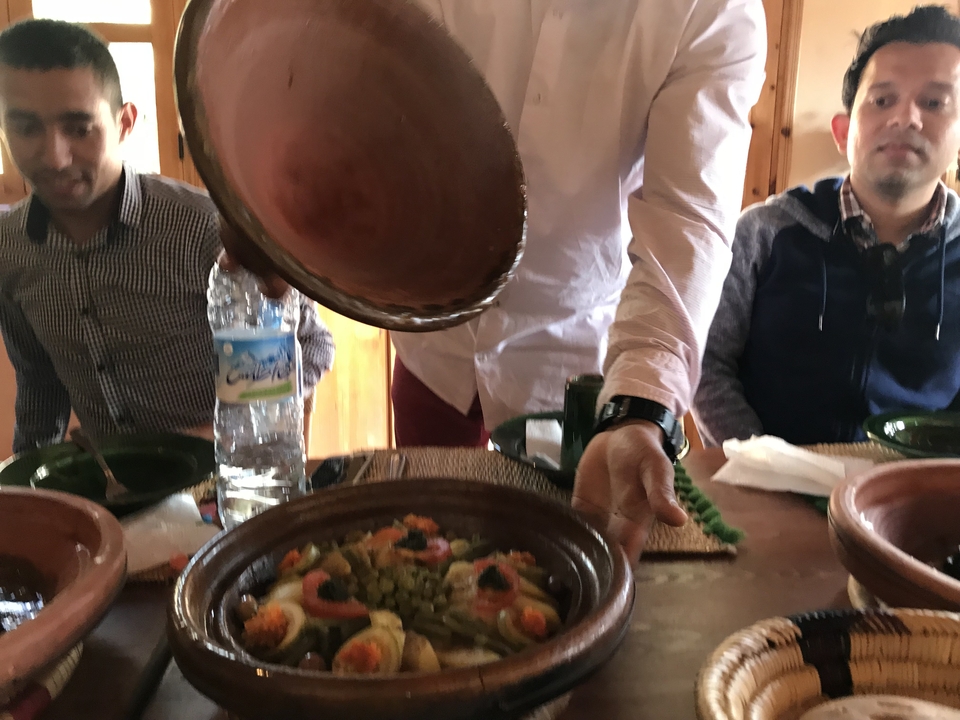 Gros plan d'une personne servant un plat traditionnel marocain.