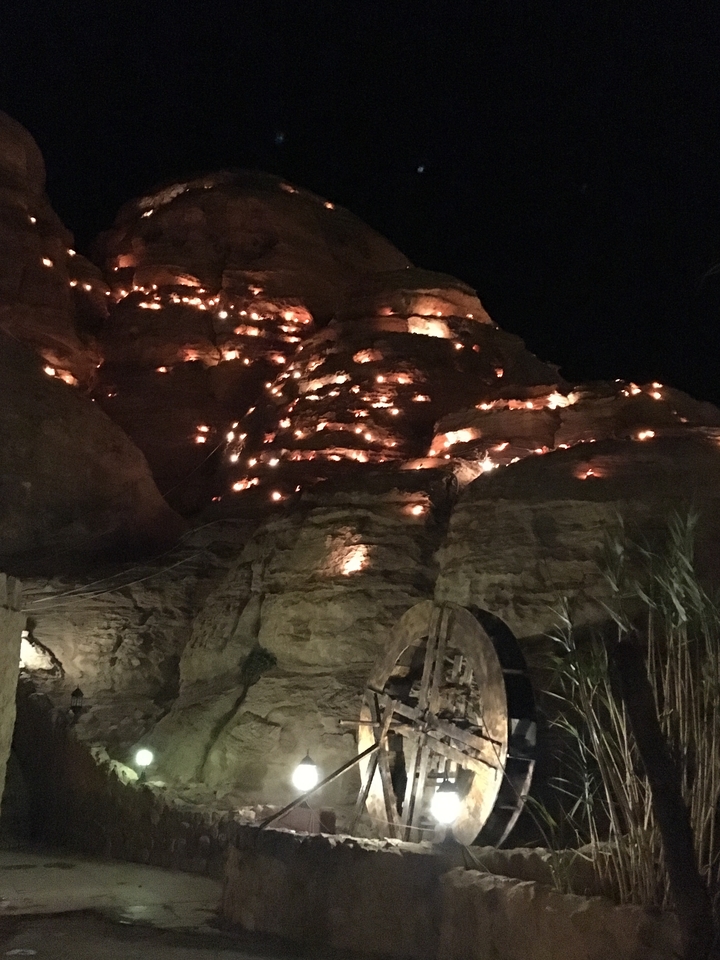 Formations rocheuses illuminées par des lanternes la nuit.