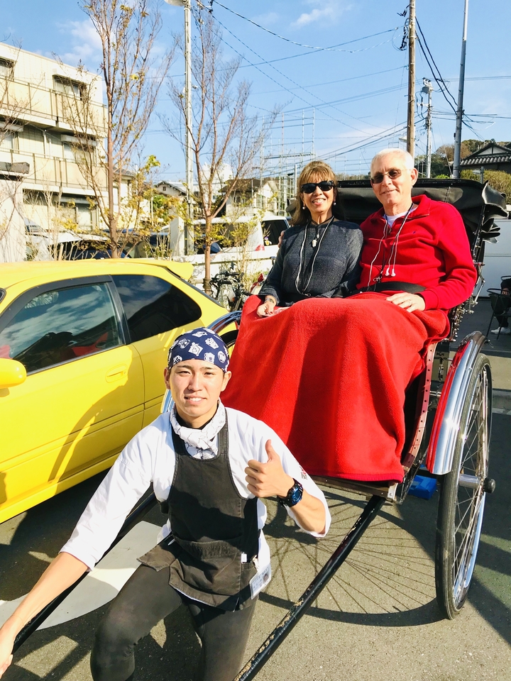 Couple dans un pousse-pousse avec un guide posant pour une photo.