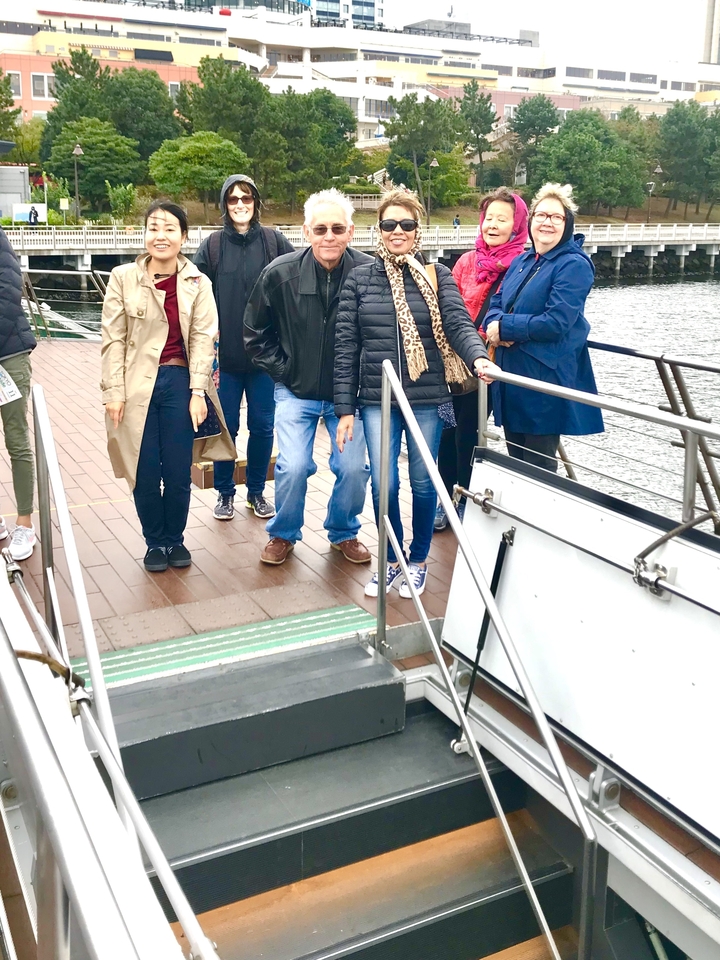 Groupe de personnes posant sur un bateau avec une rambarde.