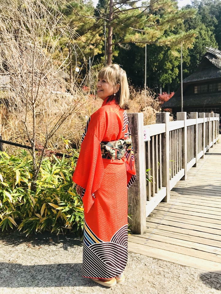 Femme en kimono posant sur un pont en bois.