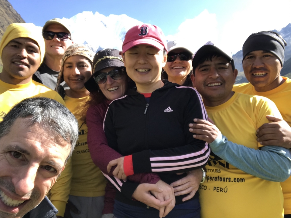 Selfie de groupe avec des randonneurs en chemises jaunes qui sourient.