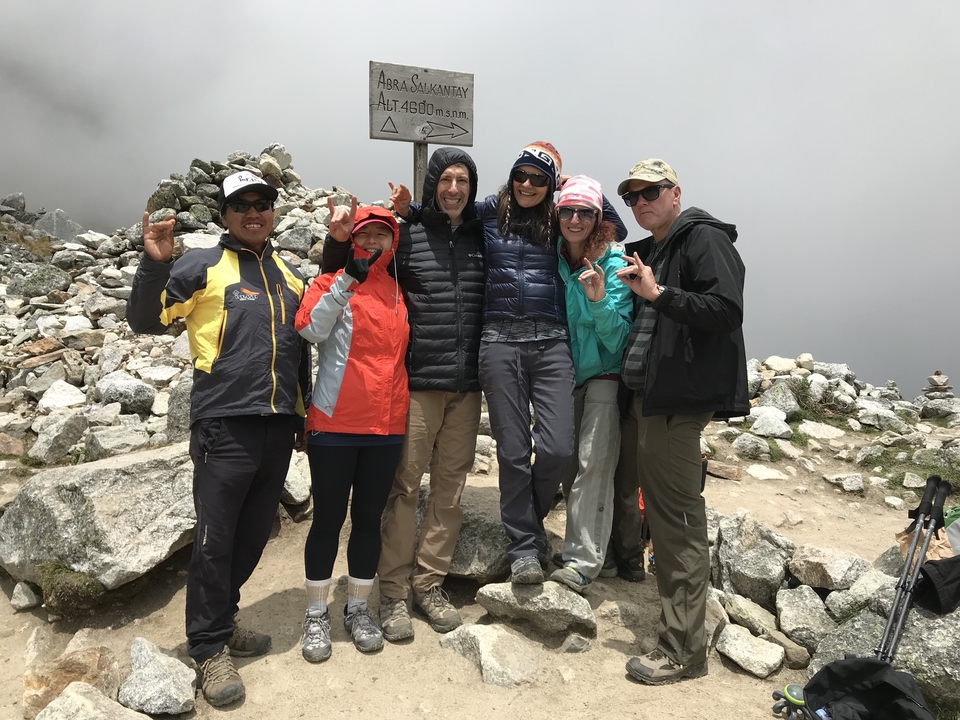Groupe de randonneurs posant sur un sentier de montagne rocheux.