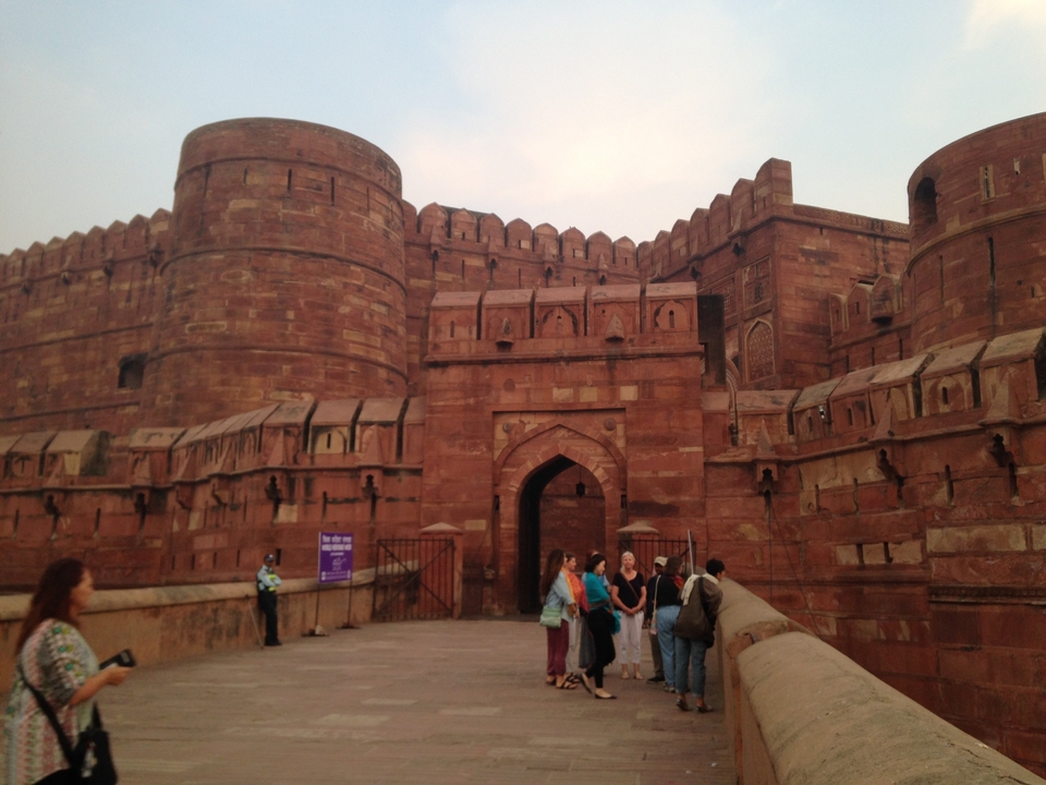 Visiteurs dans un fort historique fait de pierre rouge.